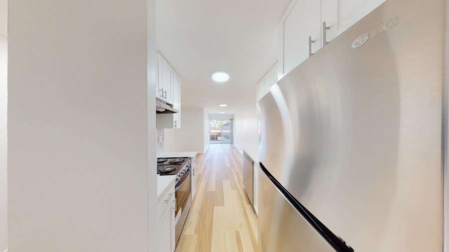 A modern kitchen with stainless steel appliances and white cabinets.